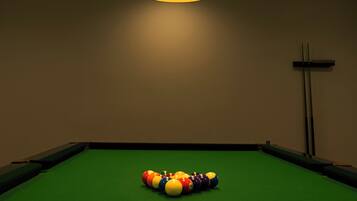 A pool table with a green felt surface and a colorful arrangement of billiard balls in the center.