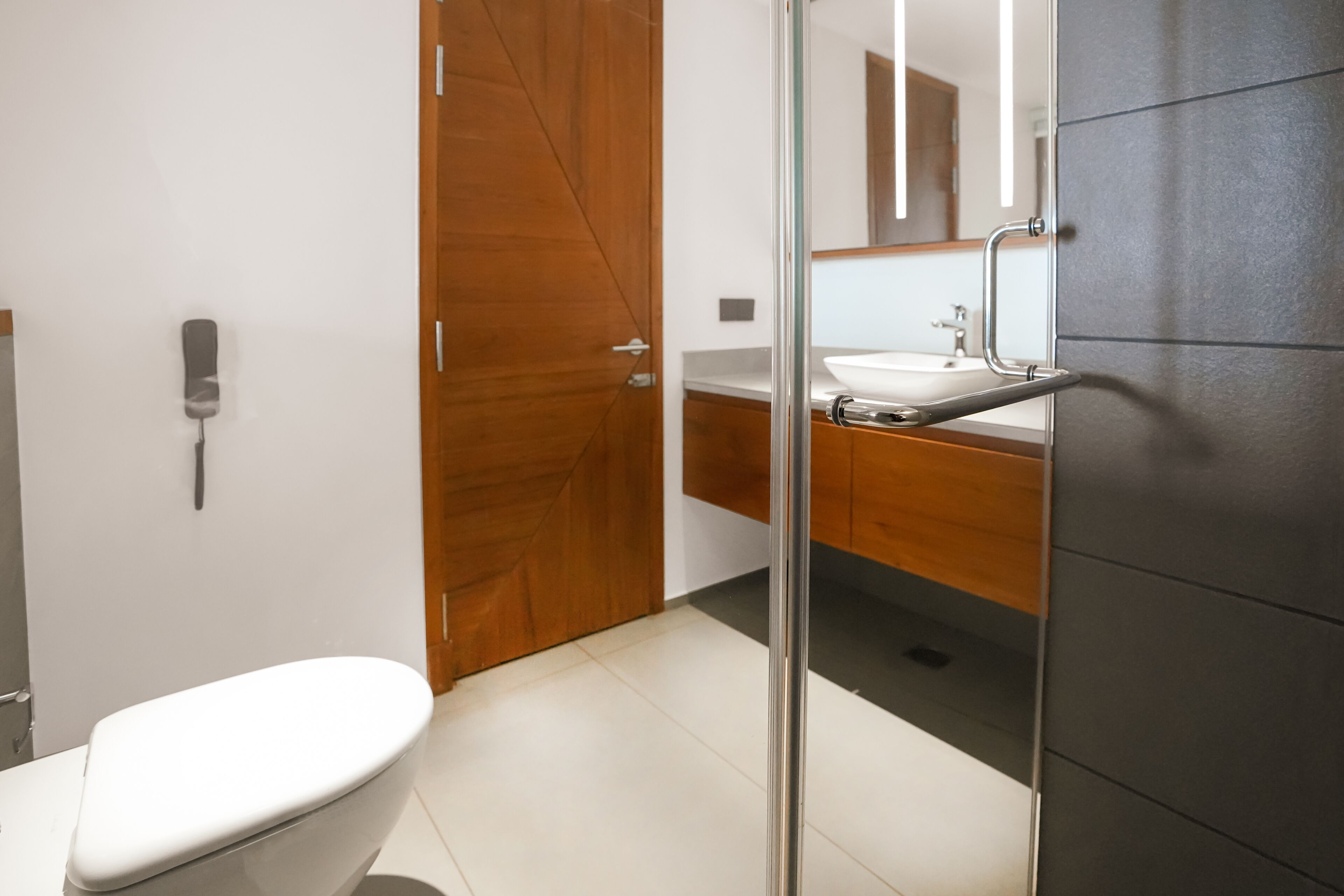 Une salle de bain moderne avec des toilettes, un lavabo et un miroir.