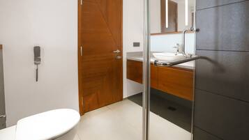 Une salle de bain moderne avec des toilettes, un lavabo et un miroir.