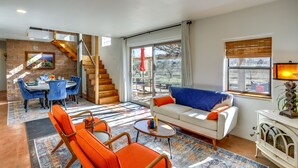 Ein modernes Wohnzimmer mit Essbereich, einer Treppe und Blick ins Freie.