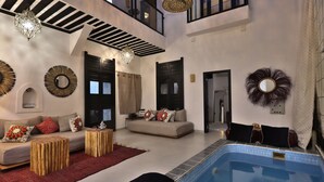 A spacious living area with a pool, modern furnishings, and a balcony. - Riad Modern bed & breakfast  (Marrakech)