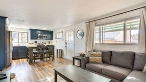 Uma sala de estar moderna com um sofá, mesa de centro e uma área de jantar com mesa e cadeiras.