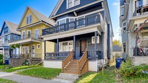 A two-story house with a front porch, a staircase, and a small front yard. - Charming Buffalo Apartment: 2 Mi to Downtown (Buffalo)