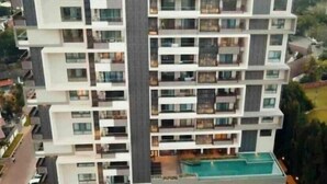 A multi-story hotel with a central courtyard and a swimming pool. - Beautiful & Spacious 1 BR Suite - Modern African Decor & Ocean View, Osu (Accra)
