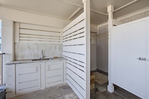A modern kitchen with white cabinetry, a marble countertop, and a tiled backsplash. - Private Pool Beach Front Sleeps 18 Family home (St, George Island)