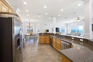 A spacious kitchen with granite countertops, wooden cabinets, and a built-in oven. - Private Pool Beach Front Sleeps 18 Family home (St, George Island)