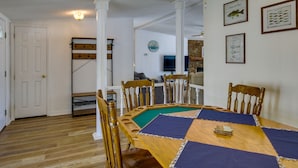 Un espace repas comprenant une table en bois, des chaises et une table de billard.