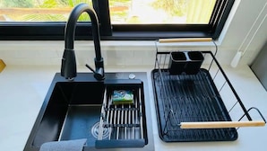A kitchen with a black sink, a kettle, and a kettle holder. - La Ventana Apartments Depa #4 (La Ventana)