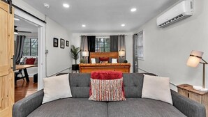 Una sala de estar moderna con un sofá, una cama de madera y un escritorio.