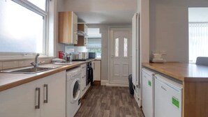 A compact kitchen with a washing machine, a dishwasher, and a sink. - Highfield House cosy 4 bedroom (Scunthorpe)