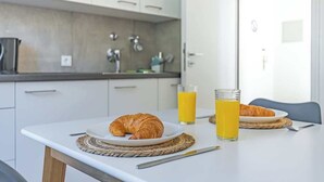 A breakfast setup with croissants, juice, and a knife on a table in a modern kitchen. - SMS-Homes I Timeout at the Alpsee-Lake (Immenstadt im Allgäu)