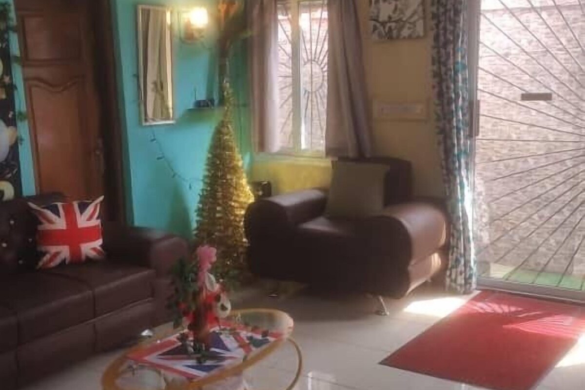 A living room with a sofa, a Christmas tree, and a coffee table.
