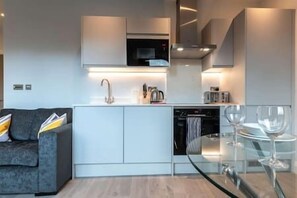 Efficient kitchen with oven, stainless steel faucet, and sleek cabinetry.