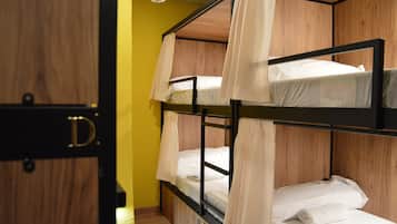 Een slaapkamer met stapelbedden, houten wanden en een deur met de tekst 'D'.