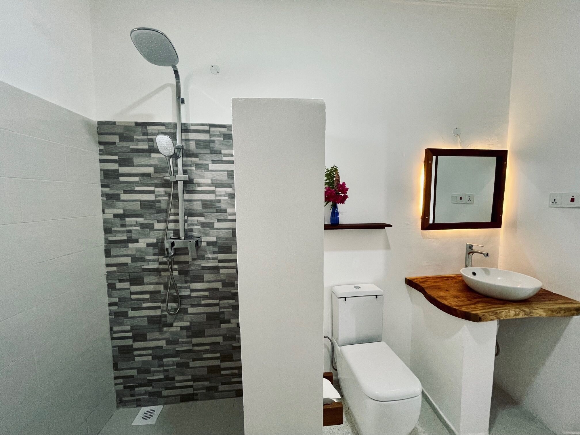 Une salle de bain moderne équipée d’une douche, de toilettes et d’un lavabo.