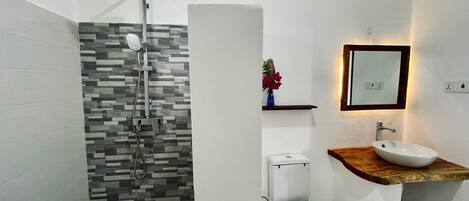 Une salle de bain moderne équipée d’une douche, de toilettes et d’un lavabo.