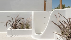 Un espacio exterior blanco con jardinera integrada y fuente de agua.