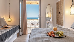Un dormitorio con cama, bandeja de desayuno y vistas a la playa.