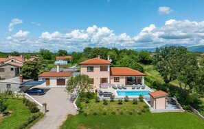 Una propiedad residencial con piscina, varias casas y una vista despejada del paisaje circundante.