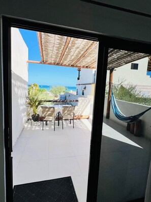 A balcony with a view of the sea, a hammock, and outdoor furniture. - La Ventana Apartments Depa #3 (La Ventana)