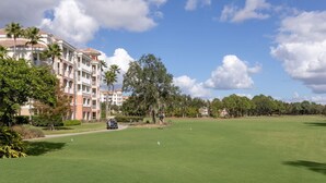 A golf course with a clubhouse and residential buildings in the background. - Marriott Grande Vista Spacious 1-Bedroom Villa Dec. 26, 2023 - Jan. 2, 2024. (Orlando)