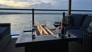 Ein Balkon mit Tisch, zwei Weingläsern und einer Weinflasche.