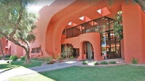 A modern building with a curved facade, large glass windows, and a well-maintained lawn. - CASA LUNA - Stunning full golf course views (Phoenix)