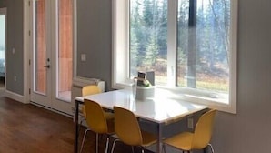 A dining area with a large window, a table, and four chairs.