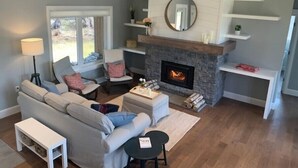 A living room with a fireplace, a sofa, a coffee table, and a lamp.