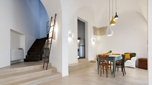 Un intérieur moderne comprenant un escalier, un coin repas et une cuisine.