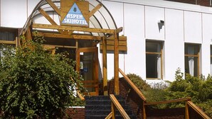 A wooden staircase leading to a building with a sign reading "Aspen Ski Hotel." - Aspen Ski Hotel (San Carlos de Bariloche)