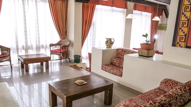 A living room with a sofa, two chairs, a coffee table, and a small table with a decorative item. - Aspen Ski Hotel (San Carlos de Bariloche)