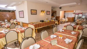 A restaurant with multiple tables, each set with white tablecloths and neatly arranged cutlery. - Aspen Ski Hotel (San Carlos de Bariloche)