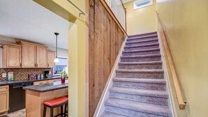A kitchen with wooden cabinets, a granite countertop, and a built-in island with red bar stools. - Newly renovated, game room, skiing, sauna, water parks, golf, suites  (Cresco)