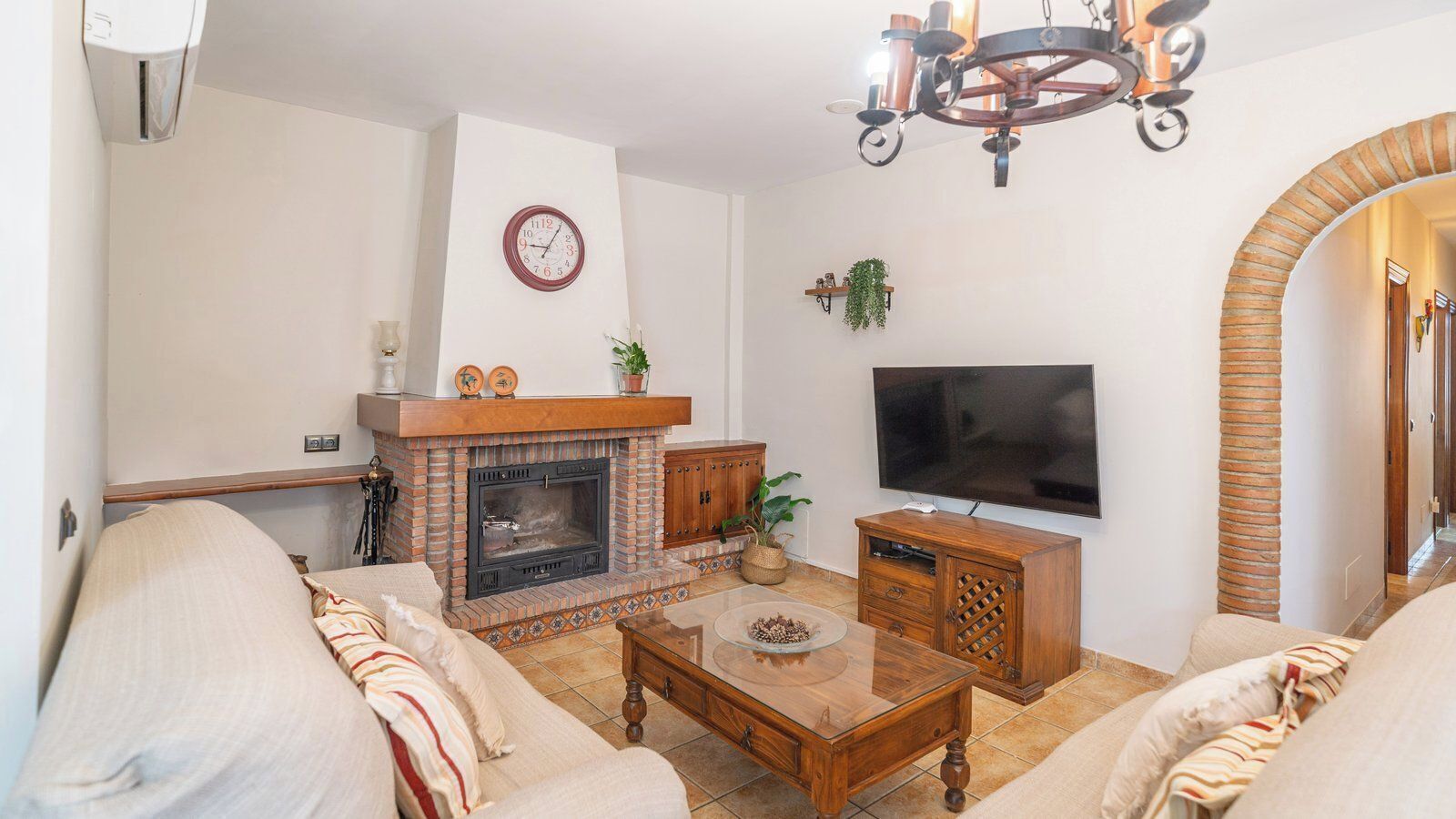 A living room with a fireplace, a TV, and comfortable seating.