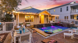 A pool area with a hot tub, lounge chairs, and a dining table set up for outdoor dining. - 3min walk to private beach access, saltwater spa & pool (Destin)