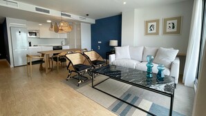 Una sala moderna con un sofá, una mesa de centro y un comedor con sillas y una mesa.
