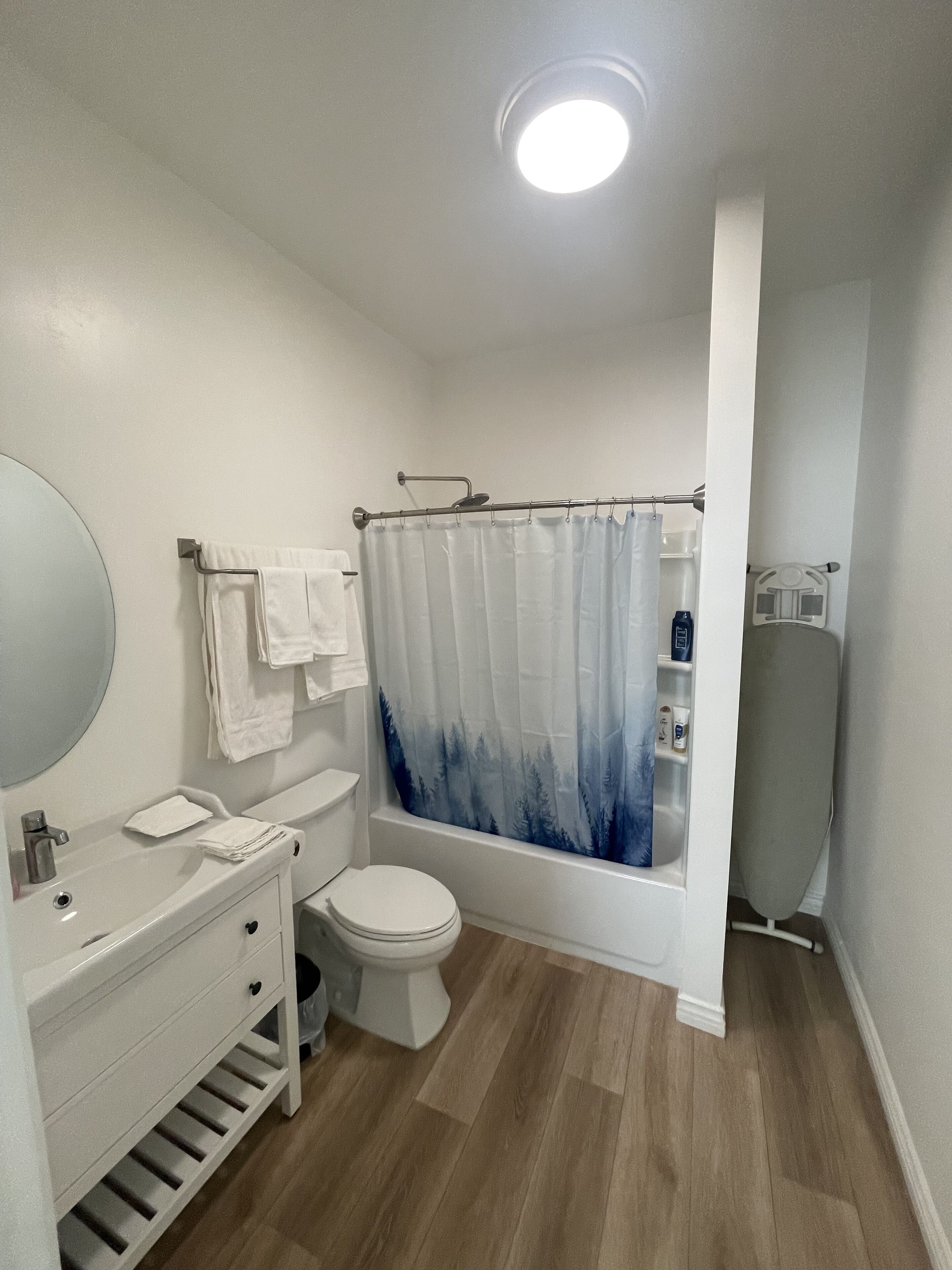 A bathroom with a white sink, toilet, and shower curtain.