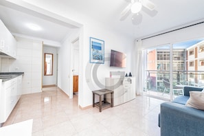 Un appartement moderne doté d’une cuisine, d’un espace de vie et d’un balcon offrant une vue sur la ville.