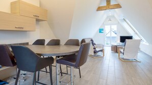 Een moderne eetruimte met een ronde tafel, meerdere stoelen en ingebouwde houten kasten.