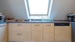 Een keuken met een dakraam, een Bosch vaatwasser en een magnetron.