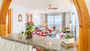 A kitchen with granite countertops, a ceiling fan, and a view to the living area. - Casa de la Vista, Best Panoramic View on the Mediterranean (Benitachell)