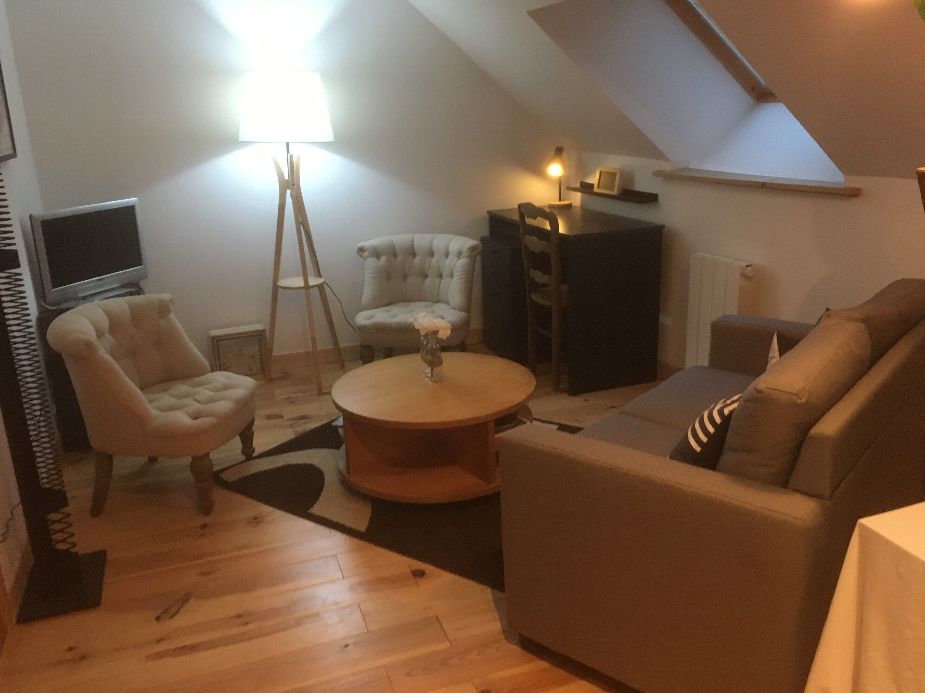 Un salon confortable avec un canapé, un fauteuil et une petite table.