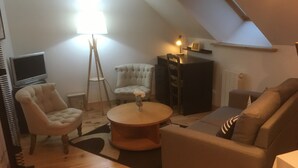 A cozy living room with a sofa, armchair, and a small table.