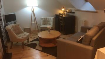 Un salon confortable avec un canapé, un fauteuil et une petite table.