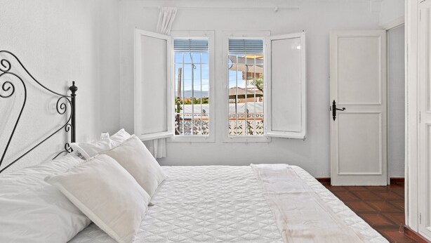 A bedroom with a bed, two windows, a door, and a view of an outdoor area. - Villa Namasté with Pool, Terraces, Near Beaches and Málaga Airport (Alhaurin de la Torre)