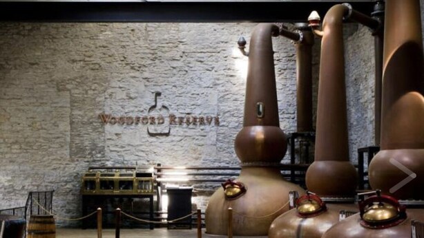 A distillery interior with large copper stills and a wooden wall with the text "Woodford Reserve". - Historic Loft in Frankfort Entertainment District (Frankfort)