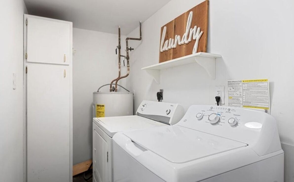 A laundry room with a washing machine, a dryer, and a water heater.