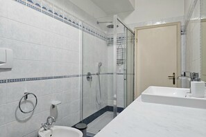 A bathroom with a shower, sink, and toilet.
