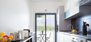 Une cuisine moderne avec un coin repas, un four encastré et une vue sur un balcon.
